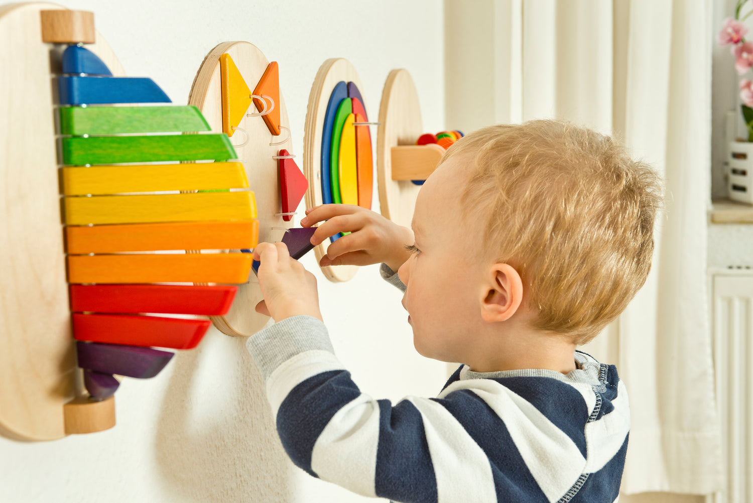 FRIDLIN Holzspielzeug, perfekte Wandspiele für Kleinkindförderung, lassen Kinderzimmer und Warteräume bunt und fröhlich erscheinen.