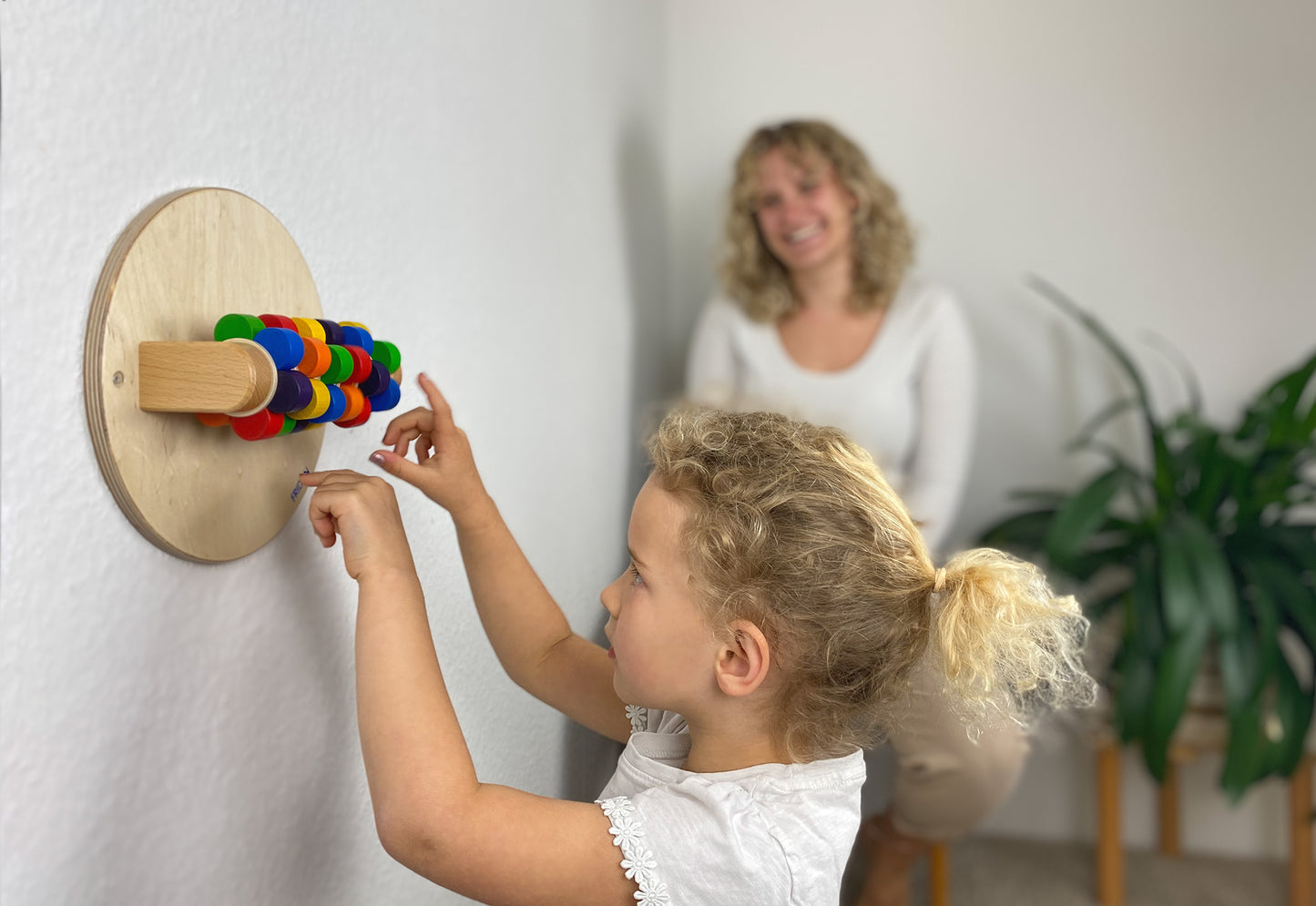 Kind spielt konzentriert mit dem FRIDLIN Drehblümchen – einem montessori-inspirierten Holzspielzeug zur Förderung der Feinmotorik und Sinneswahrnehmung.