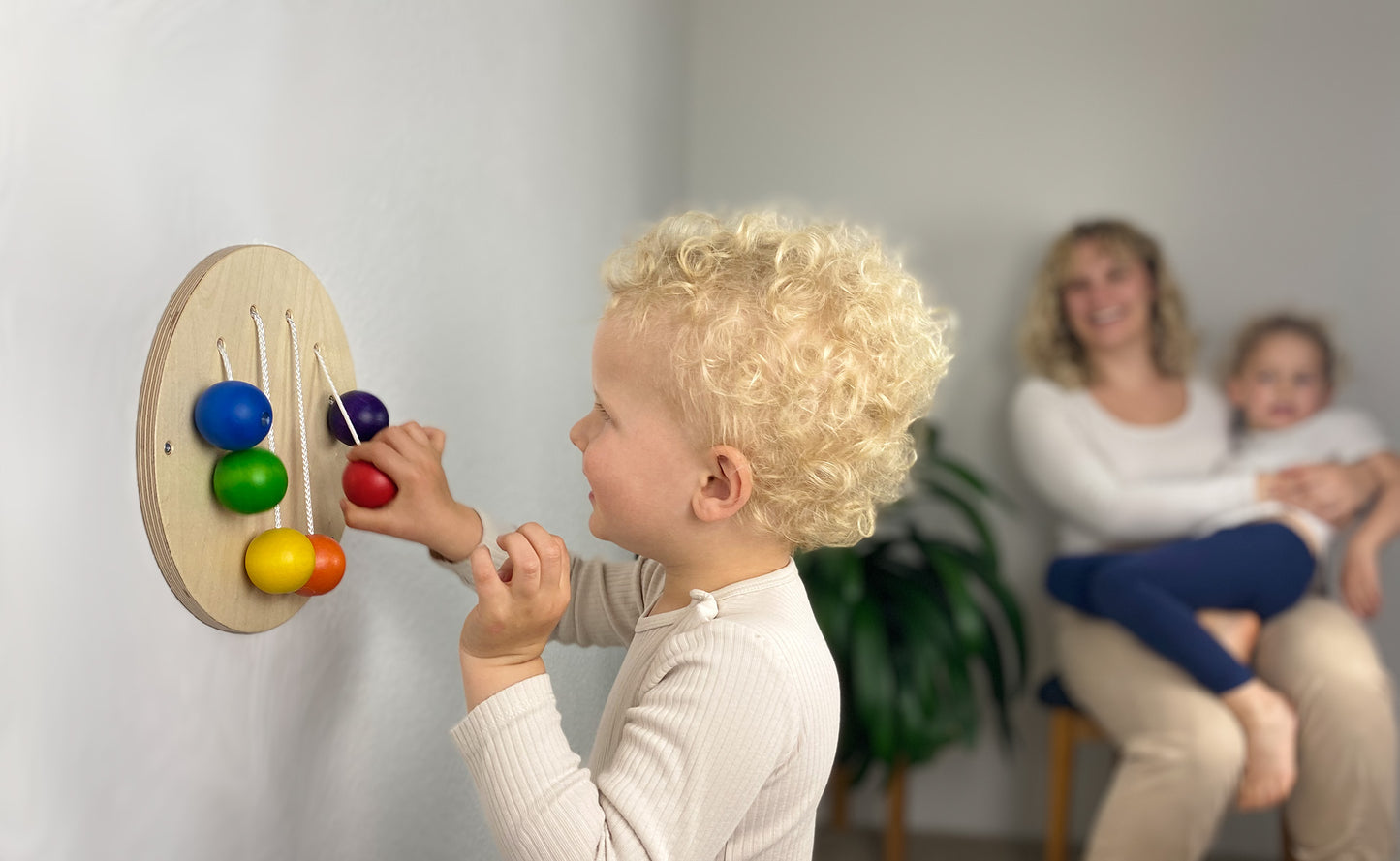 FRIDLIN Wand-Steckspiel – nachhaltiges, montessori-inspiriertes Holzspielzeug für Kleinkinder zur Förderung von Feinmotorik, Koordination und freiem Spiel an der Wand.