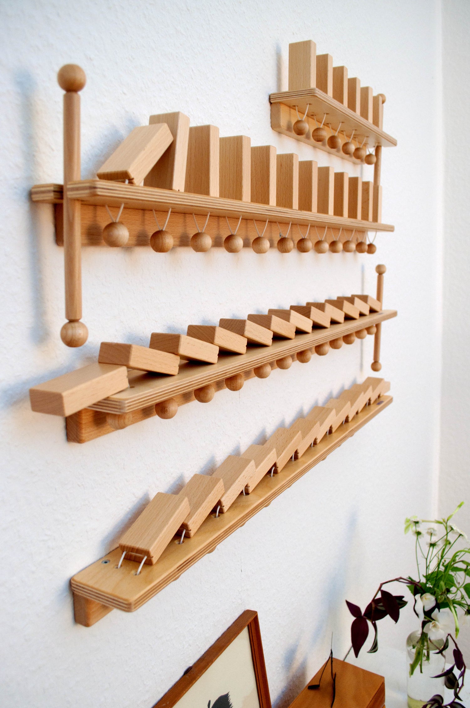 FRIDLIN Wanddomino mit Holzsteinen – montessori-inspiriertes Lernspielzeug zur Förderung von Feinmotorik und Ursache-Wirkung-Verständnis.